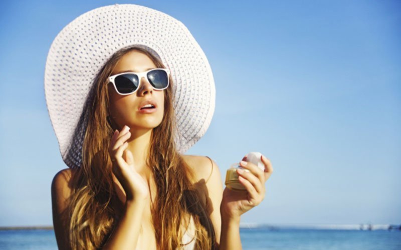 Woman apply sunscreen