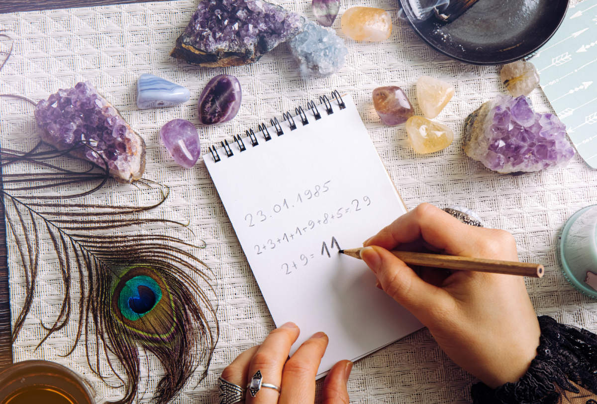 Top View Of Woman Hands Do Math, Calculate Life Path Number On Paper In Home. Result Is 11. Spiritual Numerology Concept.