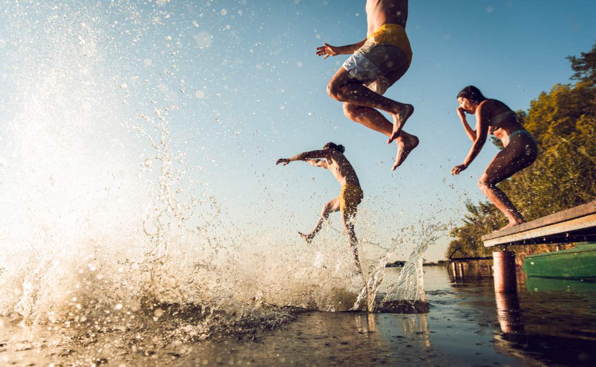 Friends Having Fun Enjoying A Summer Day Swimming And Jumping At