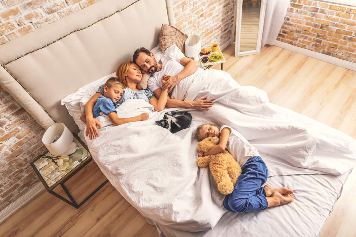 Family Sleeping Together On Bed