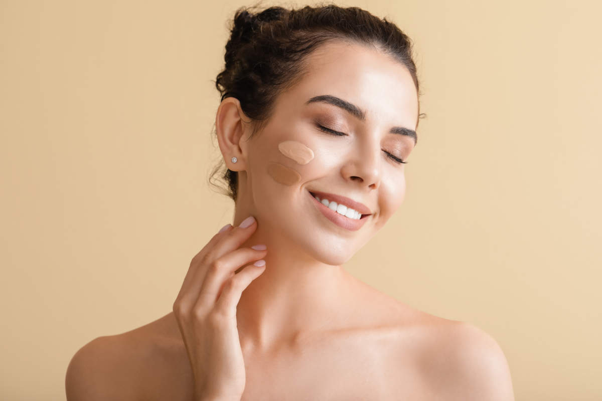 Beautiful Young Woman With Foundation On Her Face Against Color Background