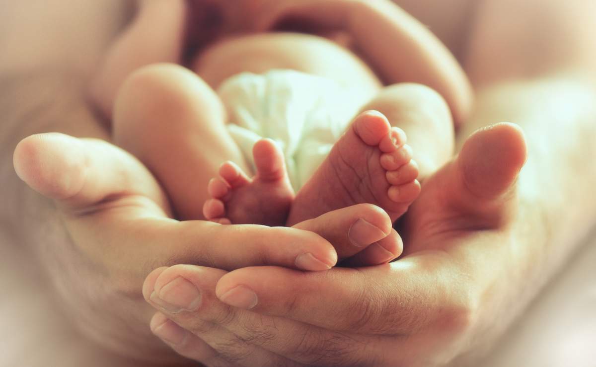 Sleeping Newborn Baby On Male Hands