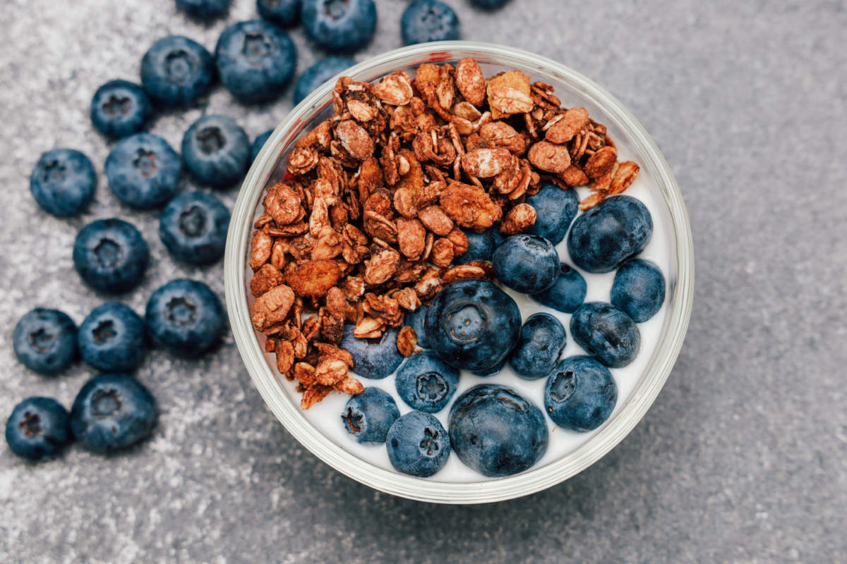 Delicious Bowl Of Yogurt Topped With Blueberries And Granola On A Gray Surface