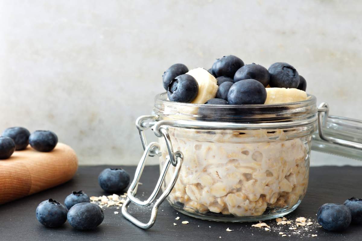 Jar Of Overnight Oats With Fresh Blueberries And Bananas, Scene With White And Black Stone Background