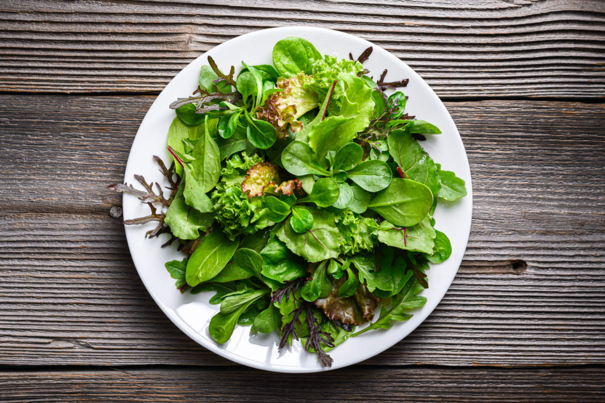 Green Salad Leaves Arranged On White Plate In Minimal Style