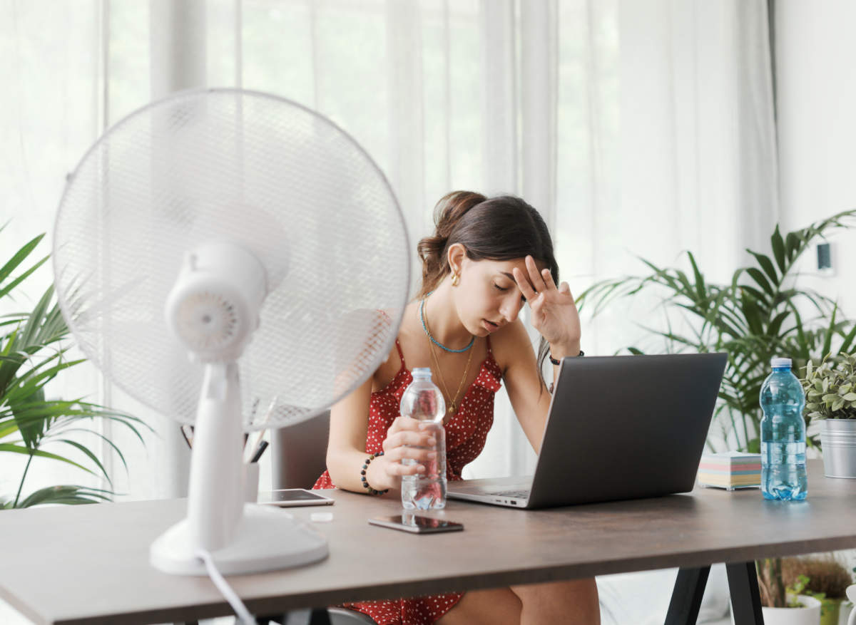 Woman Cooling Herself With An Electric Fan